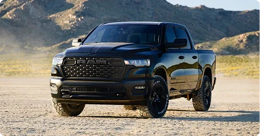 Black 2026 Ram 1500 crew cab parked on open desert ground